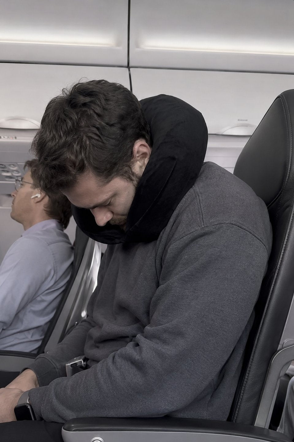 נוסע ישן במטוס עם כרית טיסה רגילה שאינה תומכת כראוי; ראשו נשמט קדימה וצווארו כפוף.
